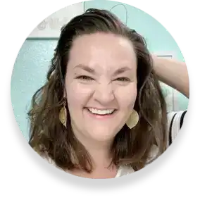 Playful close-up of Laura Funk, a real Milan Laser Hair Removal client, with her pictured holding her arm up to the back of her head in front of a light green wall